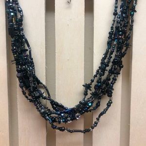 Multi String beaded necklace in shades of teals, blues, and onyxes.